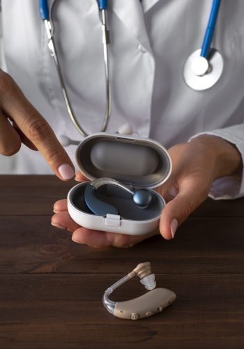 high-angle-doctor-holding-hearing-aids-case